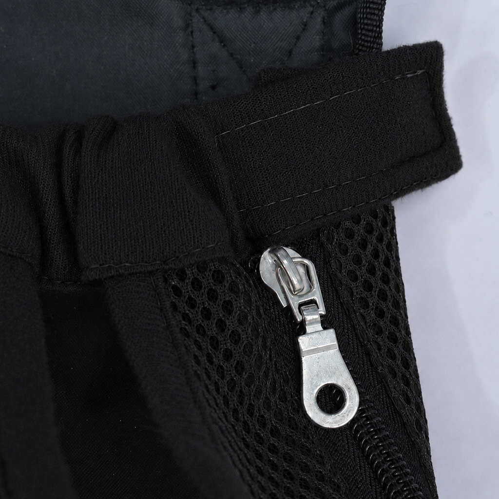 Gros plan sur la fermeture éclair latérale et la patte auto-agrippante du sac L'Éclaireur noir, en maille respirante noire